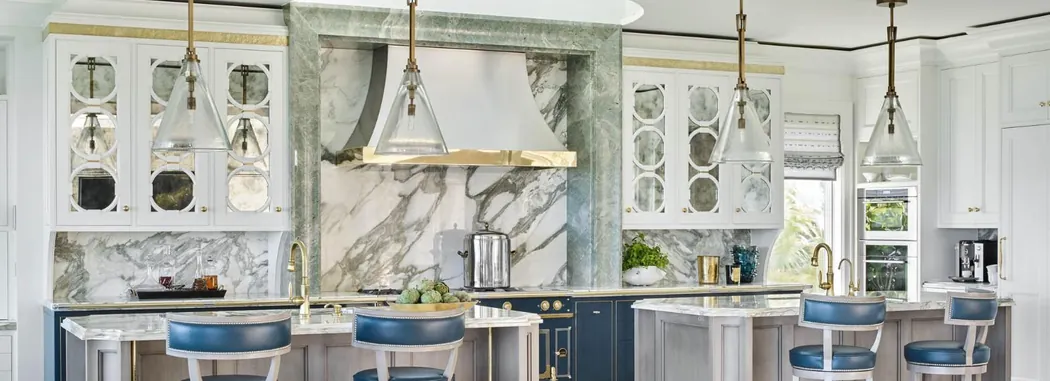 Kitchen with dramatic veined marble, antique-mirror cabinet fronts and glass pendants